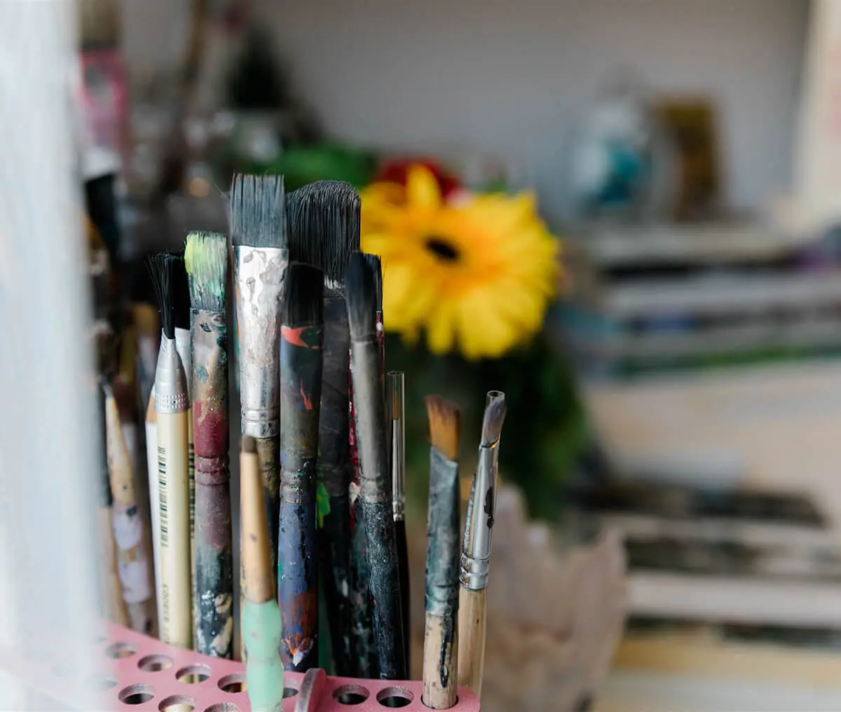 Creative workspace with brushes and flower